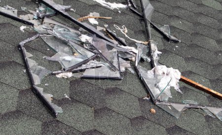 Kaputtes Dach nach Sturm. Ein großes Gebäude mit beschädigtem Dach nach einem starken Hurrikan mit Glasscherben und Fensterrahmen