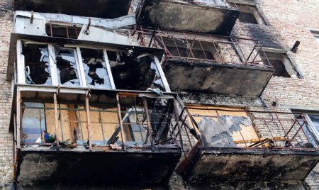 Téléchargez les photos : Appartements brûlés dans un immeuble résidentiel à plusieurs étages, les conséquences de la guerre en Ukraine. Bâtiments endommagés par des obus. Un immeuble bombardé après une frappe aérienne - en image libre de droit
