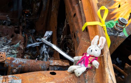 Photo for Close-up of a child's toy in ruins after a fire. A soft toy among a burned-out car. Spoiled childhood. The concept of a disaster with the death of a child. Dangerous traffic accident - Royalty Free Image