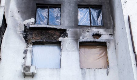 Foto de Edificios residenciales, ventanas y balcones fueron dañados por la explosión y metralla de artillería. La destrucción de la ciudad por las operaciones militares, las consecuencias de la guerra - Imagen libre de derechos
