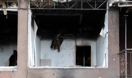 Wohnhochhaus nach starkem Brand. Wohnungen und Balkone wurden durch das Feuer zerstört, nachdem eine Rakete eingeschlagen war. Fassade eines verlassenen Hochhauses nach einem Brand