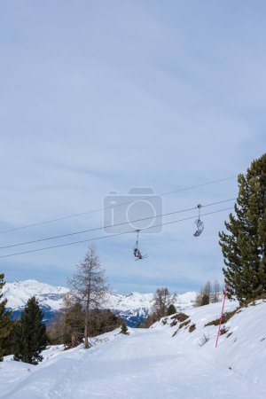 Photo for Focus on two chairlifts in winter with undefined skiers in ski resort St. Luc in Wallis Switzerland. - Royalty Free Image