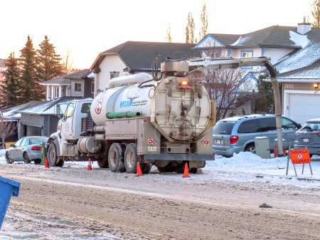 Photo for Calgary, Alberta, Canada Nov 9, 2022. A Hydro excavation trucks or hydrovac using water to break up the ground and vacuuming to remove the soil onsite during the winter. - Royalty Free Image