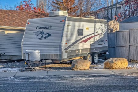 Téléchargez les photos : Calgary, Alberta, Canada. Jan 25, 2023. An RV toy haulers trailer parked in front a house during winter. Concept: recreational vehicle - en image libre de droit