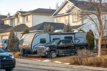 Foto de Calgary, Alberta, Canada. Jan 25, 2023. An RV fifth wheel trailer parked in front a house during winter. Concept: recreational vehicle - Imagen libre de derechos