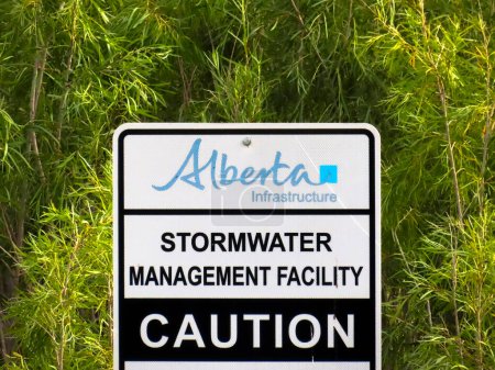 Téléchargez les photos : Calgary, Alberta, Canada. Jul 19, 2023. An Alberta Infrastructure, Stormwater Management Facility Caution Sign. - en image libre de droit