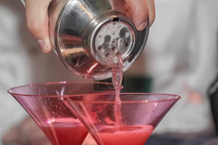 Foto de Un camarero hábilmente elaborar una bebida mezclada, elegantemente verter en un vaso de martini. - Imagen libre de derechos