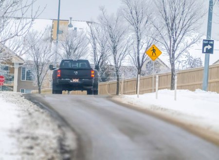 Foto de Calgary, Alberta, Canadá. Feb 8, 2024. Una perspectiva hacia atrás de un camión Dualie 6x4, con ruedas traseras duales, atravesando las condiciones invernales de la carretera. - Imagen libre de derechos