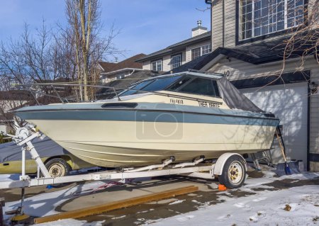 Photo for Calgary, Alberta, Canada. Feb 29, 2024. A boat is stationed in the front garage of a residence during the winter season. - Royalty Free Image