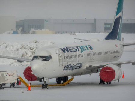 Photo for Calgary, Alberta, Canada. Mar 22, 2024. A close up to the Westjet at the Calgary International Airport plane during winter. - Royalty Free Image