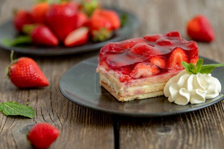 Téléchargez les photos : Pièce de gâteau aux fraises sur une planche en bois. Rouge Brun blanc - en image libre de droit