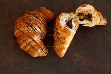 Croissant con mantequilla dos piezas en un tablero negro. Foto de alta calidad