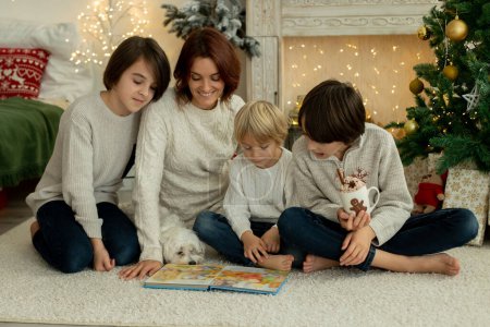 Foto de Familia feliz con tres niños y perro, sentado en casa en Navidad, ambiente acogedor, tiempo de Navidad - Imagen libre de derechos