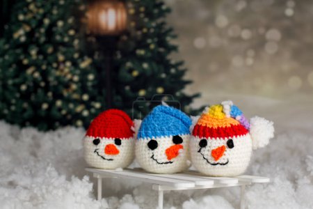 Photo for Little cute handmade snowman head with colorful hats on a sledge in the snow - Royalty Free Image