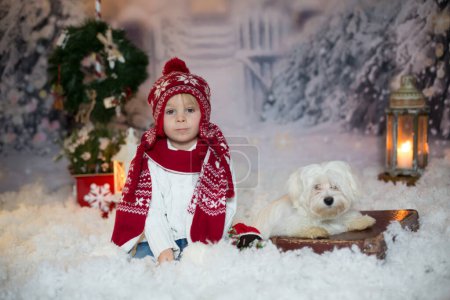 Photo for Blond toddler child with christmas clothes , walking in the snow, playing with knitted toy - Royalty Free Image