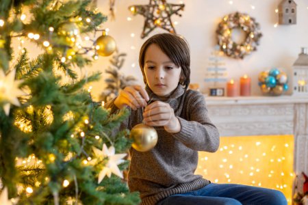 Foto de Lindo niño, niño, jugando en la habitación decorada para Navidad, la decoración de la Navidad tre - Imagen libre de derechos