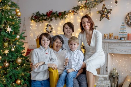 Photo for Christmas family picture in cozy home with lights and decoration, grandmother, mother and children - Royalty Free Image