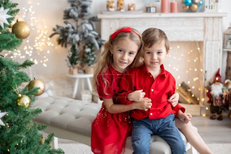 Téléchargez les photos : Happy cute children, siblings on Christmas, enjoying holiday, opening presents and eating cookies - en image libre de droit