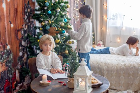 Téléchargez les photos : Bonne famille, enfants et maman, profiter de Noël ensemble dans une maison confortable, décorée avec décoration de Noël - en image libre de droit