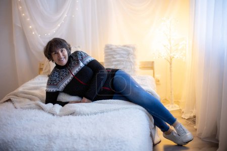 Foto de Elderly woman, posing at home, sitting on sofa or bed - Imagen libre de derechos