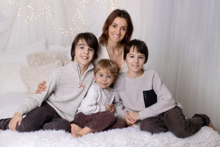 Photo for Family portrair of mother with her three children on white, little lights behind them - Royalty Free Image