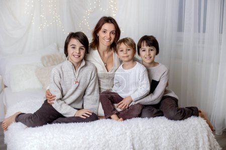 Photo for Family portrair of mother with her three children on white, little lights behind them - Royalty Free Image