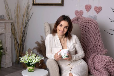 Téléchargez les photos : Middle age woman, drinking coffee in a nice cozy living room at home - en image libre de droit