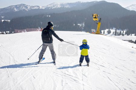 Happy family, skiing in Italy on a sunny day, kids and adults skiing together. Family vacation