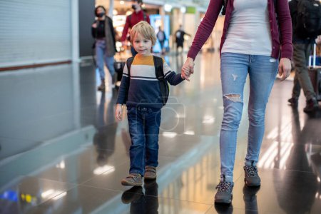 Photo for Cute  baby boy waiting boarding to flight in airport transit hall near departure gate. Active family lifestyle travel by air with child on vacation - Royalty Free Image