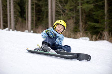 Photo pour Petit garçon tout-petit, enfant d'âge préscolaire, skiant pour la première fois sur une petite piste de ski - image libre de droit
