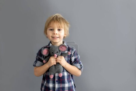 Téléchargez les photos : Petit enfant en bas âge, garçon blond, jouant avec petit jouet en tricot rembourré fait à la main - en image libre de droit