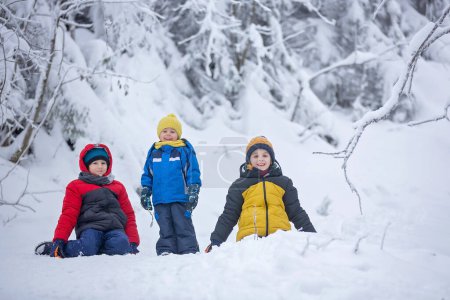 Photo for Sweet happy children, brothers, playing in deep snow in forest, frosted trees and beautiful landscape - Royalty Free Image