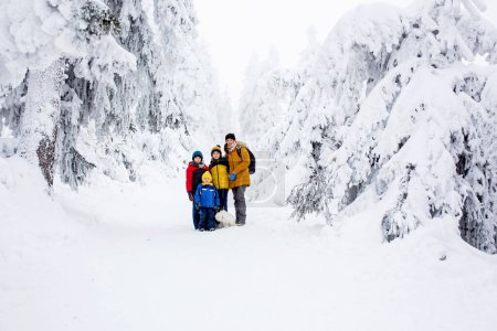 Foto de Familia feliz con niños, senderismo en las montañas invierno, mucha nieve, hermoso bosque de invierno con nieve profunda - Imagen libre de derechos