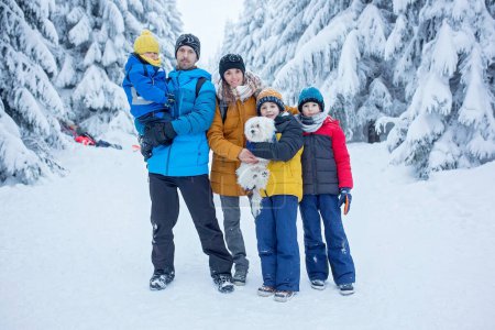 Téléchargez les photos : Happy famille witn enfants, randonnée dans les montagnes l'hiver, beaucoup de neige, belle forêt d'hiver avec neige profonde - en image libre de droit