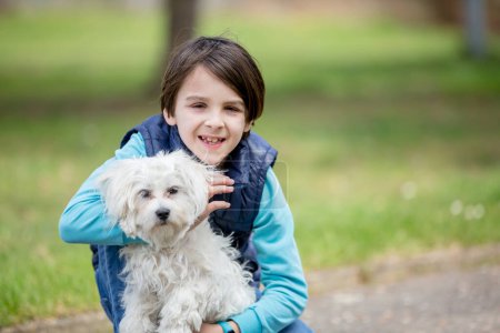 Foto de Lindo niño preadolescente, abrazando a su perro mascota en el parque amor y cuidado - Imagen libre de derechos