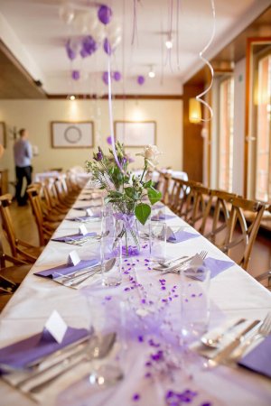 Foto de Elegante configuración de mesa en pasteles púrpura para una boda de restaurante, en interiores - Imagen libre de derechos