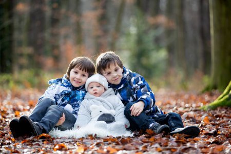 Téléchargez les photos : Portrait de trois garçons, frères, dans la forêt, automne hiver - en image libre de droit