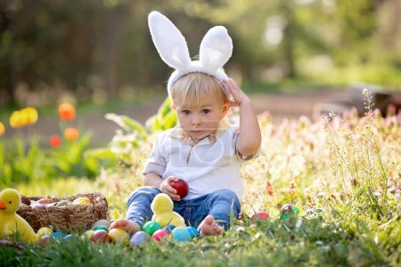 Foto de Dulce niño pequeño con orejas de conejo, la caza de huevos para la Pascua, el niño y las tradiciones del día de Pascua. Niños y vacaciones - Imagen libre de derechos