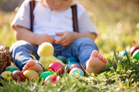 Foto de Dulce niño pequeño con orejas de conejo, la caza de huevos para la Pascua, el niño y las tradiciones del día de Pascua. Niños y vacaciones - Imagen libre de derechos