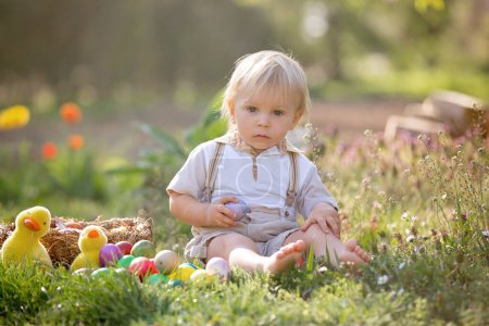 Téléchargez les photos : Petit garçon doux avec des oreilles de lapin, chasse aux œufs pour Pâques, enfants et traditions du jour de Pâques. Enfants et vacances - en image libre de droit