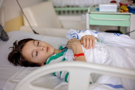 Téléchargez les photos : Enfant préadolescent, garçon, allongé à l'hôpital avec fracture de la colonne thoracique, vertèbres, mère assise à côté de son lit - en image libre de droit