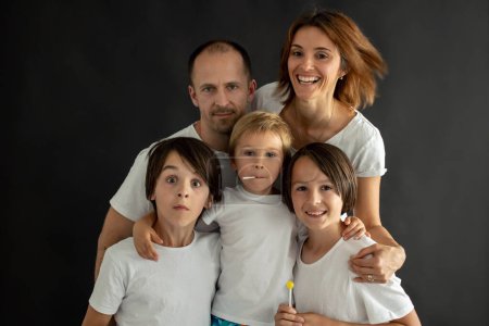 Téléchargez les photos : Portrait isolé d'un enfant et de ses parents,, famille, personnes heureuses sur fond noir - en image libre de droit