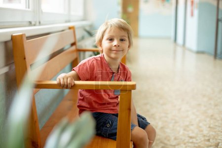 Foto de Niño en edad preescolar, sentado en un escritorio en la escuela, teniendo lección, aprendiendo cosas nuevas - Imagen libre de derechos