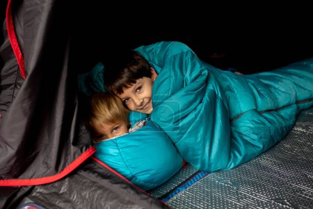 Foto de Children, sibilngs, sleeping in sleeping bags in a tent in Norway, wild camping - Imagen libre de derechos