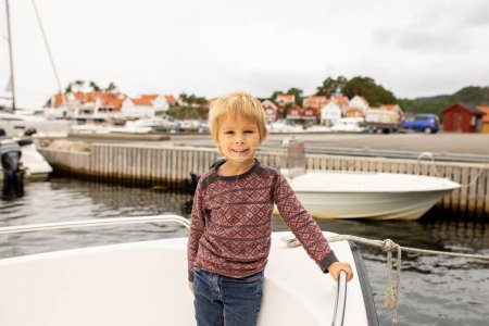 Photo for Toddler child, enjoying the view over beautiful small village in south Norway on a cloudy day - Royalty Free Image