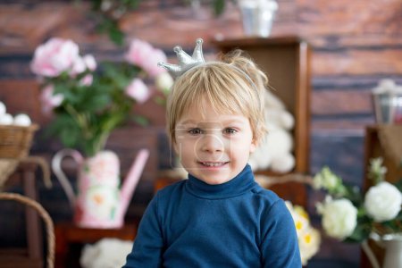 Foto de Hermoso niño rubio, con una pequeña corona, fingiendo ser príncipe, niño jugando juegos imaginarios - Imagen libre de derechos