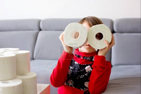 Kind spielt zu Hause mit Toilettenpapier