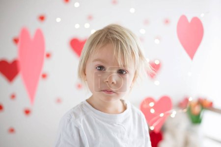 Foto de Lindo niño rubio, caja de espera en forma de corazón y rosas flores - Imagen libre de derechos