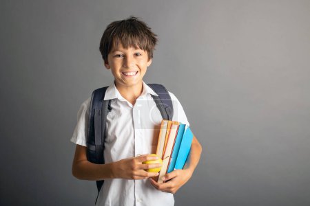 Photo for Cute preschool blond child, boy, holding books and notebook, apple, wearing glasses, ready to go to school - Royalty Free Image