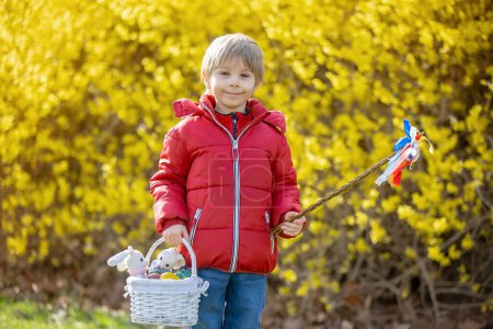 Photo for Cute preschool child, boy, holding handmade braided whip made from pussy willow, traditional symbol of Czech Easter used for whipping girls and women to receive eggs and sweets - Royalty Free Image